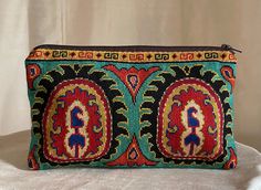 a colorful embroidered purse sitting on top of a white table