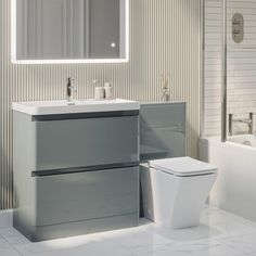 a white toilet sitting next to a sink in a bathroom under a mirror above it