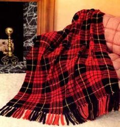 a red and black plaid blanket sitting on top of a bed