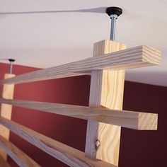 a ceiling fan mounted to the side of a wooden beam in a room with red walls