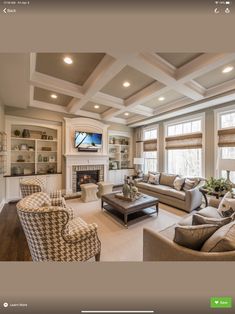 a living room with couches, chairs and a tv in it's center