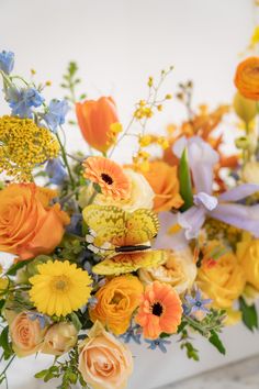 yellow decorative butterfly with orange yellow and pastel purple blue flowers in a white container on a marble table Background Color Palette, Green Marble Table, Outdoor Wedding Centerpieces, Oncidium Orchid, Yellow Flower Arrangements, Oncidium Orchids, Green Baby Shower, Wedding Colors Blue, Green Colour Palette