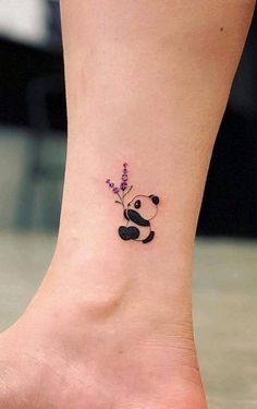 a small tattoo on the ankle of a girl with a panda bear and lavender flowers