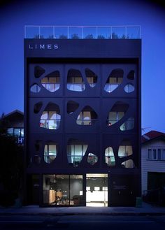 the building has many windows on each side and is lit up by night time lights