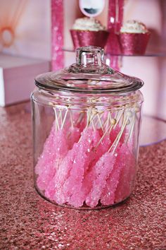 pink candy sticks in a glass jar on a counter