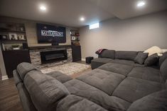 a living room filled with furniture and a flat screen tv mounted on the wall above a fire place