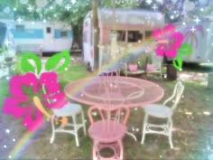 a pink table and chairs in front of a camper with flowers on the back