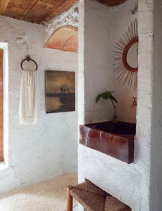 a bathroom with a sink, mirror and towel hanging on the wall next to it