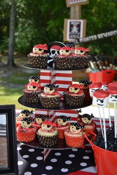 a table topped with lots of cupcakes covered in minnie mouse decorations