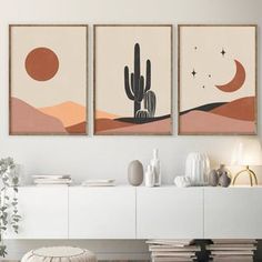 two paintings are hanging on the wall above a white cabinet in a modern living room