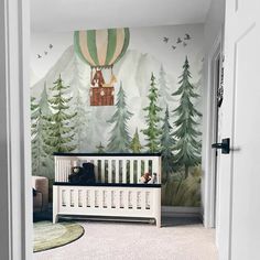 a baby's room with a wall mural depicting a hot air balloon in the sky