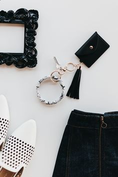 a black and white photo frame with a tassel keychain next to it