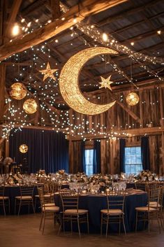 the reception tables are set up with blue linens and stars hanging from the ceiling