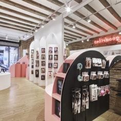 the inside of a store with pink shelves and pictures on display in front of it