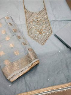 Item Overview ATHARVA Hand Embroidered Salwar Kameez w/Beautiful Embroidered Neck Grey/Banarsi Silk Dupatta/Latkan Tassel/Wedding/Bridal Trousseau Dno. CH1415 Fabric: * Shirt Chanderi Silk in Grey - 2.5 Mts, with Embroidered Neck * Dupatta: Banarsi Silk Dupatta - 2.5 Mts - (Motifs may wary) * Bottom Santoon Silk 2.5 Mts. Excusive Hand Embroidered Party Wear Punjabi Suit. Customization: * Fabrics Customization: Designs Can be made in different Fabrics. * Color Customization: Designs Can be made i Embroidered Sets For Wedding And Diwali, Wedding Kurta With Resham Embroidery And Kundan, Ceremonial Embroidered Jamawar Churidar, Ceremonial Embroidered Churidar In Jamawar, Embroidered Dola Silk Sets For Wedding, Wedding Sets With Zari Work On Chanderi, Wedding Sets In Dola Silk With Embroidery, Wedding Sets With Embroidery In Dola Silk, Gold Embroidered Jamawar Kurta