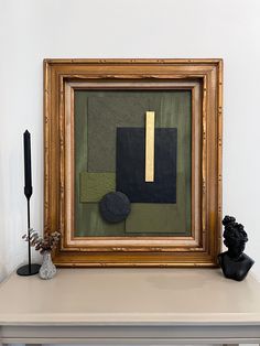 a painting sitting on top of a white table next to a vase and black object