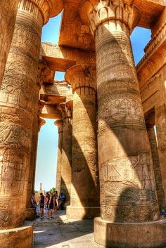 an image of people walking around in the ancient city with large columns and carvings on them