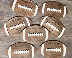 six wooden football coasters with coach's name on them sitting on a table