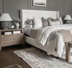 a bedroom with gray walls and white bedding