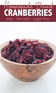 a wooden bowl filled with cranberries on top of a white table next to the words homemade dried cranberries keto low carb - carb - sugar - free