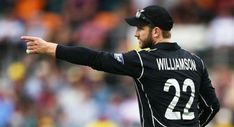 a man in black jersey throwing a ball on top of a field with crowd watching