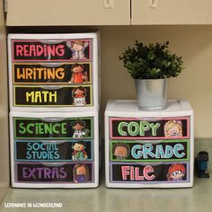 three colorful boxes with writing on them and a potted plant