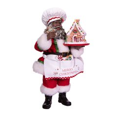 a man dressed as santa clause holding a gingerbread house