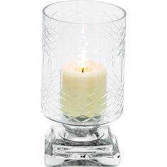 a small glass candle holder with a single lit candle in the center on a white background