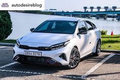 a white car parked in front of a body of water