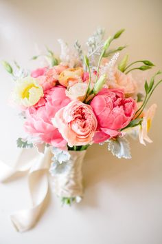 a bouquet of pink and yellow flowers in a vase