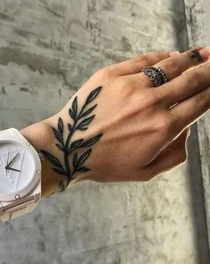 a woman's hand with a tattoo on it and a watch in the other hand