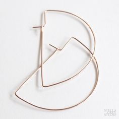 A modern take on a classic hoop earring, these hand forged earrings are simple in design & high on style. Perfect, understated, elegant. Material choices: 14k yellow gold filled, 14k rose gold filled, or sterling silver. Size: approx. 2.5" long x 1.5" wide Due to the handmade nature of these earrings, no two will be exactly the same and may vary slightly from the picture. Just like your eyebrows, these are sisters, not twins. // Best Candle Scents, Grey Studio, Pendulum Earrings, Wire Hoop Earrings, Candle Scents, Earring Hoops, Earring Wire, Wire Jewelry Designs, Hoops Gold