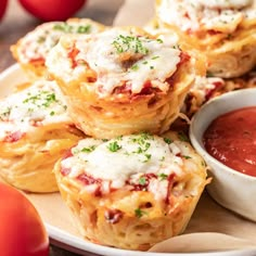 several mini pizzas with cheese and sauce on a plate