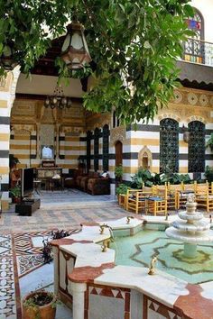 an ornate courtyard with fountain and seating area