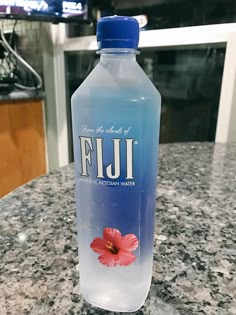 a bottle of fiji water sitting on top of a counter