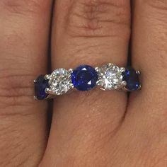 a woman's wedding ring with three stone sapphires and two diamonds on it