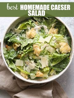 a bowl filled with lettuce and cheese on top of a cloth covered table