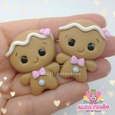 two little baby dolls are sitting in the palm of someone's hand with hearts around them