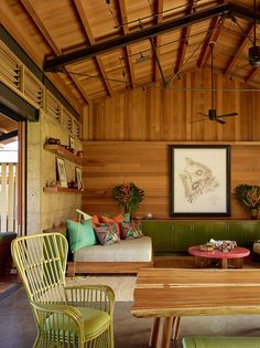 a living room filled with lots of furniture next to a wooden ceiling mounted above a window