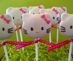 hello kitty lollipops are sitting on top of each other in the grass