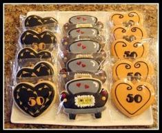 decorated cookies in the shape of cars and hearts are displayed on a tray with plastic wrappers