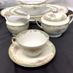 a table topped with plates and bowls filled with food next to a black table cloth