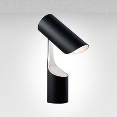 a black lamp with a white light on the top and one arm in the shape of a cone