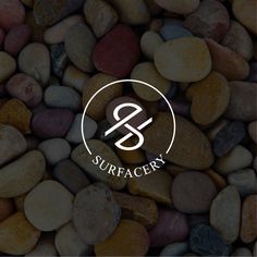 the logo for surfacery is surrounded by small rocks