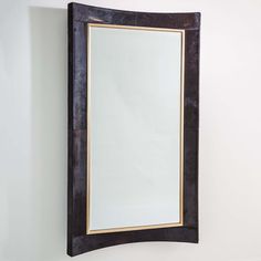 a mirror hanging on the wall next to a white wall with a black frame and gold trim