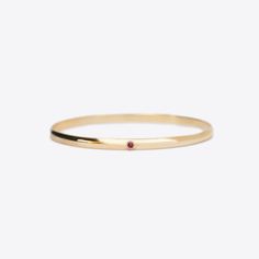 The Milestone bangle with the addition of one bezel set birthstone. A beautiful piece to add to your stack for a celebration or to represent children or grandchildren. A 4mm solid 14k gold half round bangle with a flat interior.Stone Details: 2.5mm natural birthstones totaling approximately .1tcw The stones in our jewelry are always natural/earth mined, with the exception of Alexandrite, which is lab grown. We source lab grown Alexandrite to ensure high quality and consistent and fair pricing. T 14k Gold Wedding Bangle With Single Diamond, Yellow Gold Birthstone Ring With Smooth Bezel As Gift, 14k Gold Jewelry With Smooth Bezel And Round Stone, Minimalist Stackable Round Band Bracelets, Minimalist Stackable Bracelets With Round Band, Yellow Gold Classic Bangle With Gemstone, Classic Yellow Gold Bangle With Gemstone, Classic Gemstone Bangle For Anniversary, Dainty 14k Gold Stackable Bangle