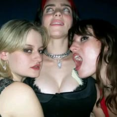 three women are posing for the camera with their mouths open and one woman has her tongue out