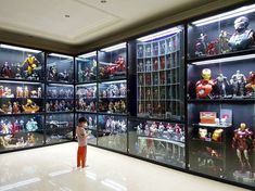 a little boy standing in front of a display case filled with action figures