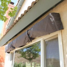 an image of a window that is being installed on the side of a house with a cover over it