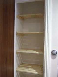 an empty closet with shelves in it and the door open to reveal another room that has no one inside